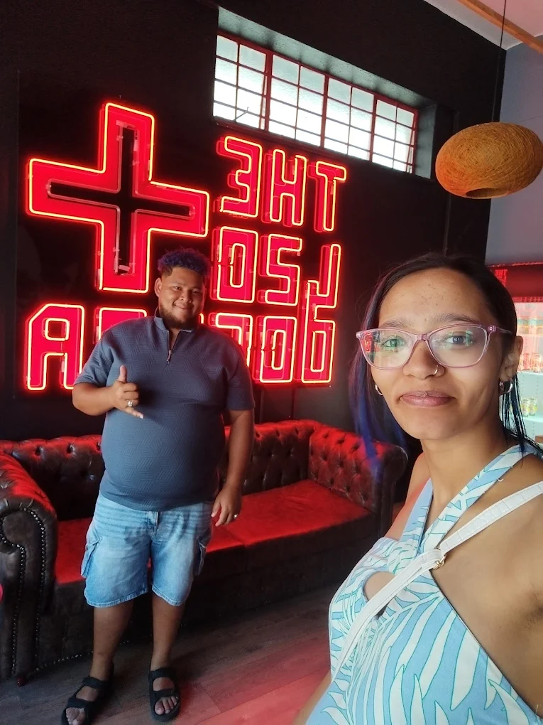 customers posing at the 420 doctor neon sign